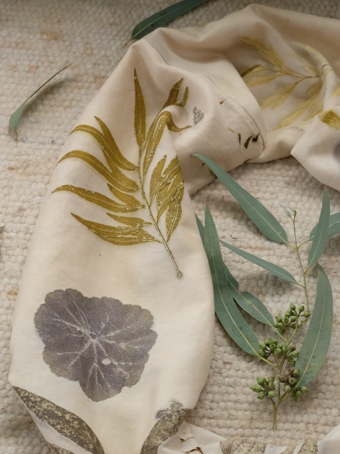 section of an ecoprinted scarf with leaves of grenvilla, geranioum and eucalyptus.