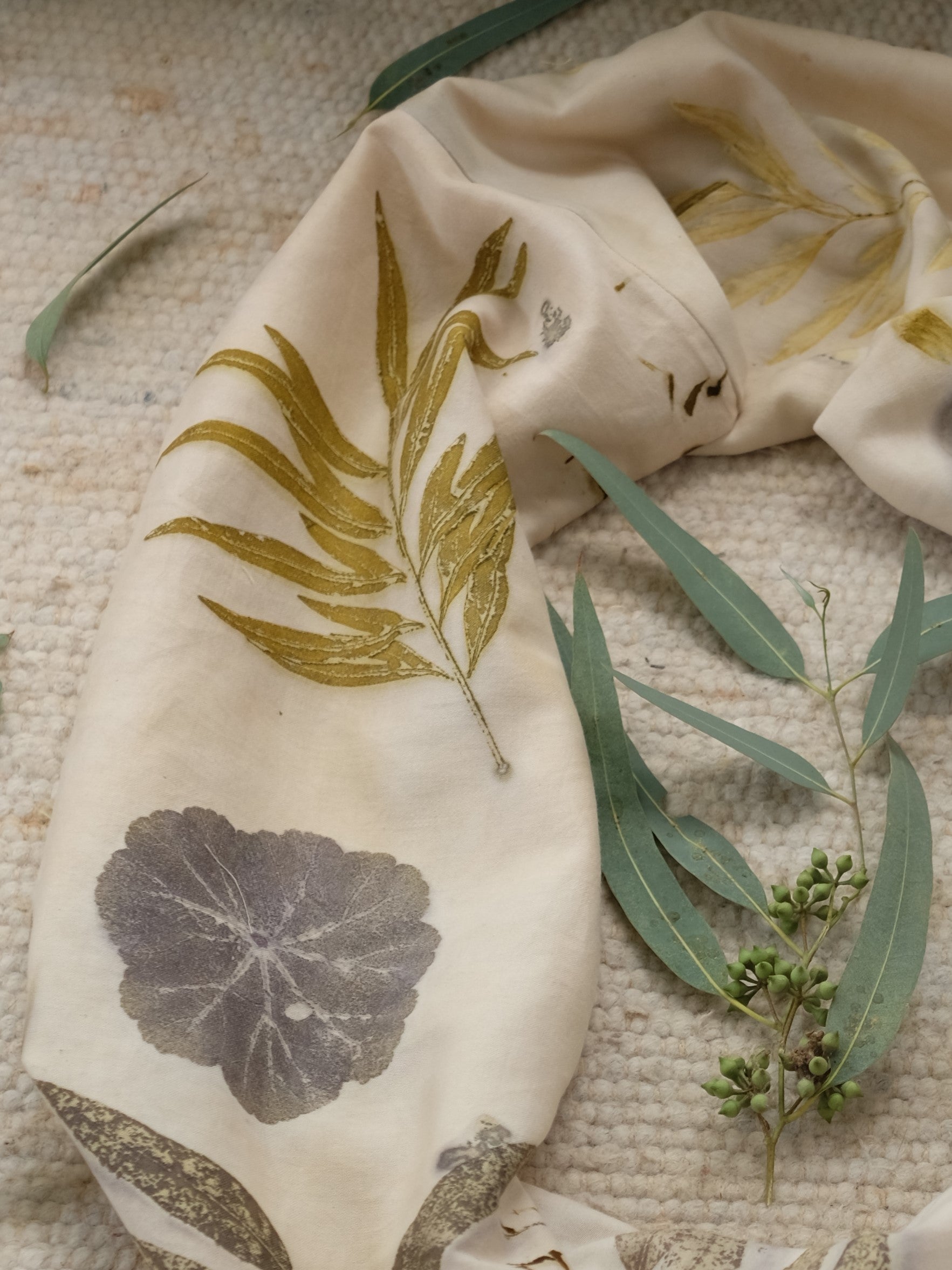 section of an ecoprinted scarf with leaves of grenvilla, geranioum and eucalyptus.