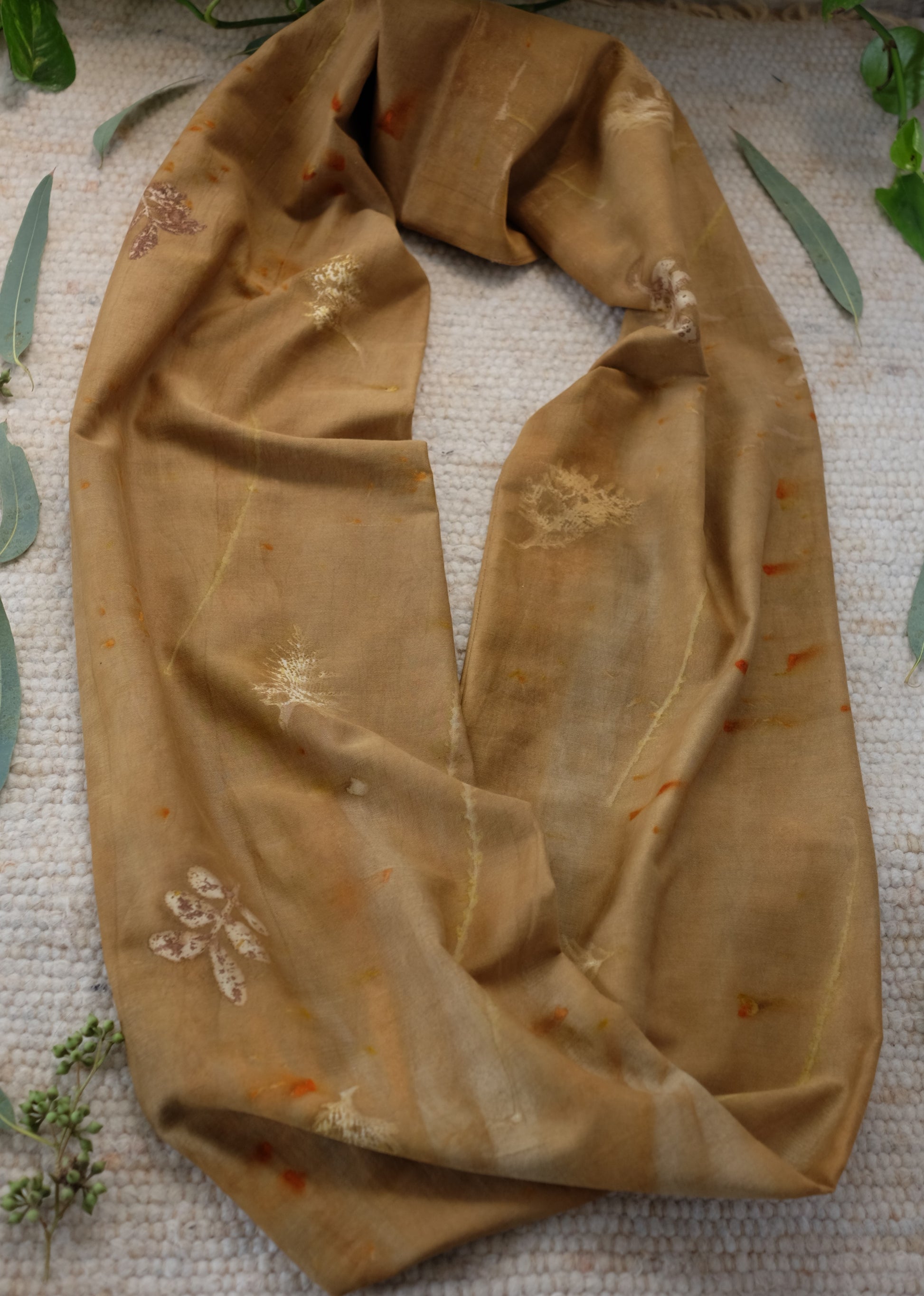 ecoprinted infinity scarf in brown color with beighe and orange  prints. 