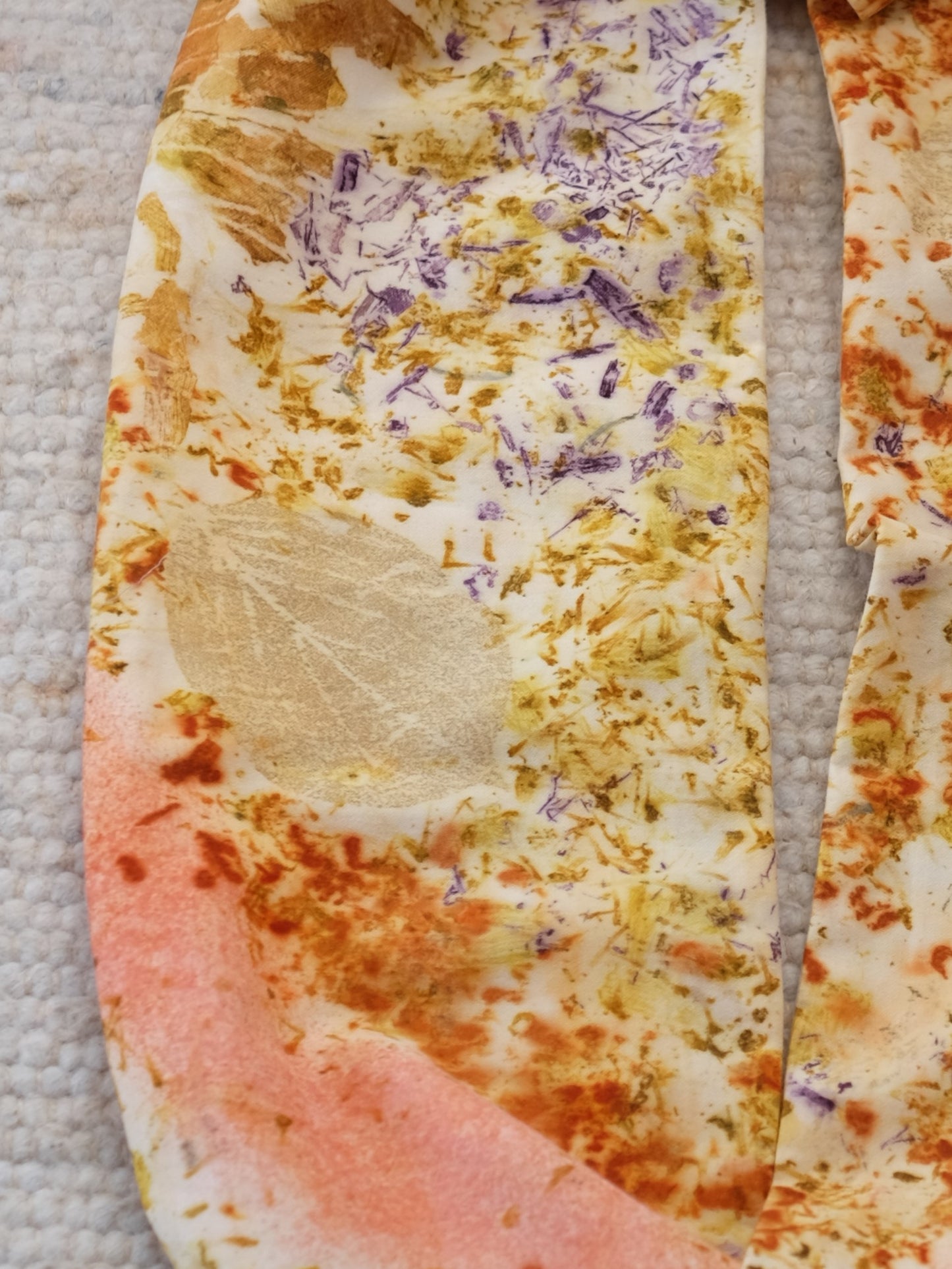 detail froma  bundle dyed scarf with logood, marigolds, madder and cosmos flowers.