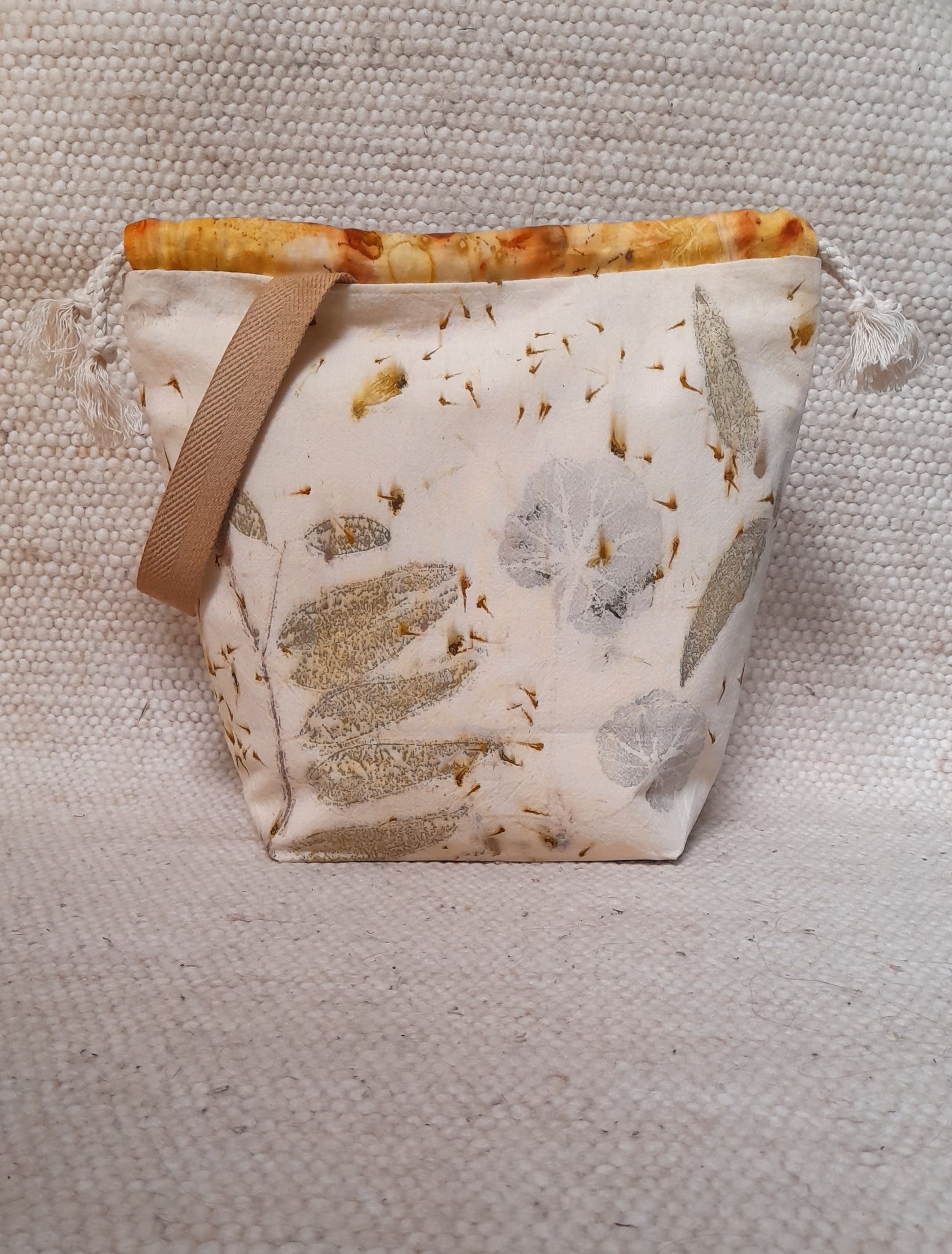 ecoprinted bag with different leaves in a white backround.