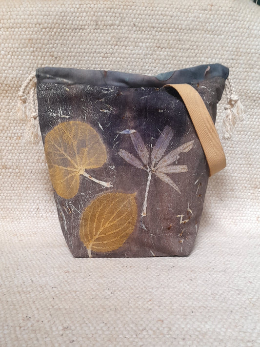 handmade project bag with ecoprinted fabric. various leaves in a dark grey/blue background.