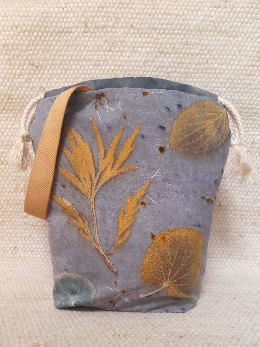 handmade bag with ecoprinted fabric, various leaves in a blue background.